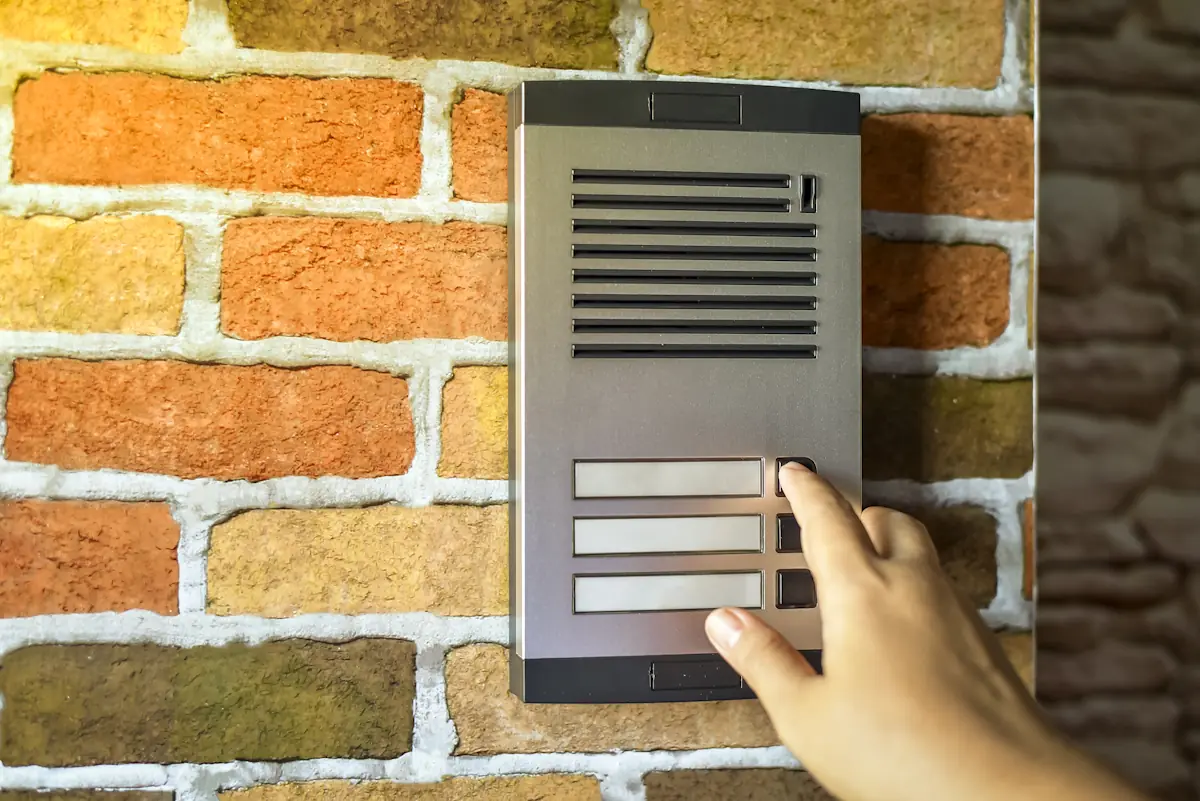 Une personne qui appuie sur un bouton de Interphone immeuble