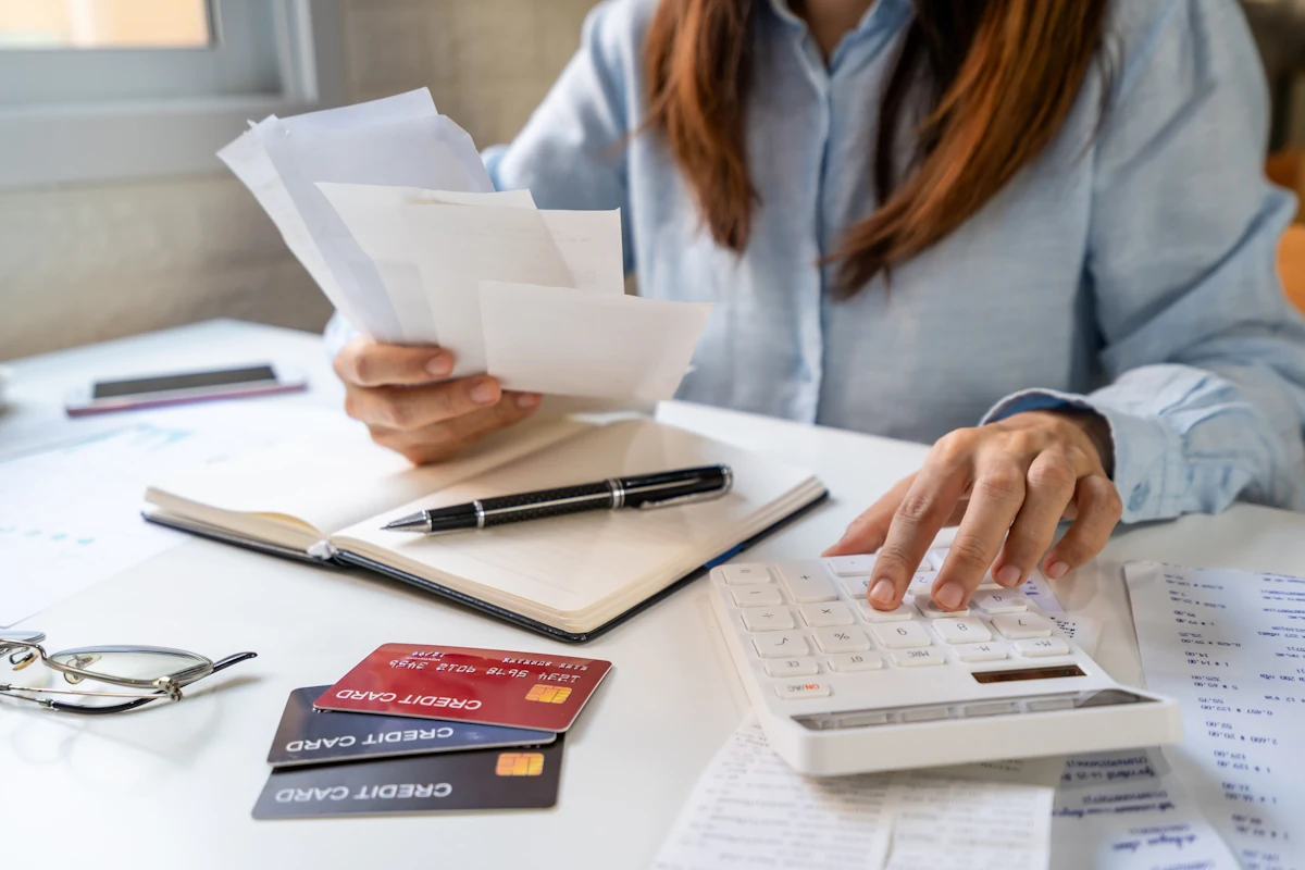 Une femme qui calcule ses dettes pour demander une rénégociation