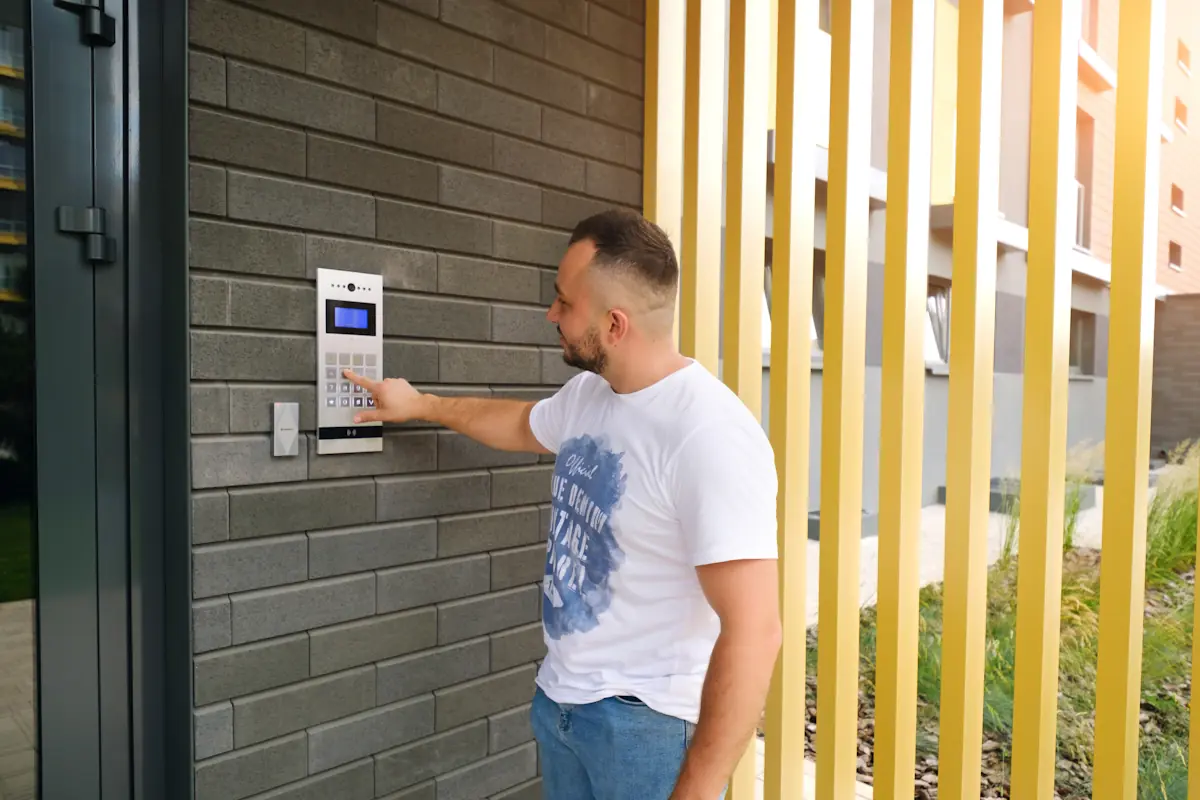 Un homme qui utilise un clavier à code sur un système de contrôle d'accès d'immeuble