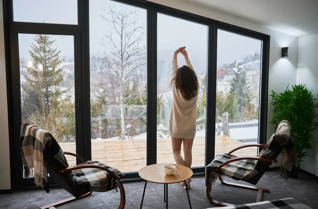 Une femme qui se tient devant une baie vitrée